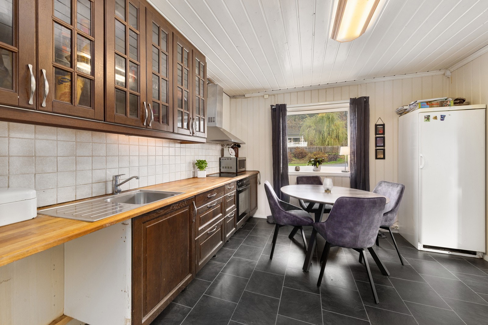 Eldre kjøkken med profilerte fronter og heltre benkeplate. Galleribilde