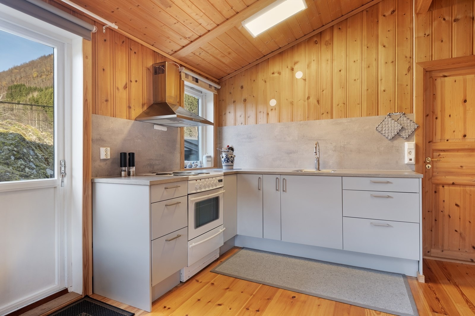 Kjøkkendelen har innreiing med glatte frontar og benkeflate av laminat. Galleribilde