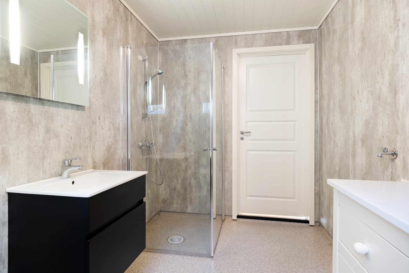 Badet inneheld klosett, nedfeltservant med underskuffer, dusjhjørne med glasdører og opplegg for vaskemaskin. Galleribilde