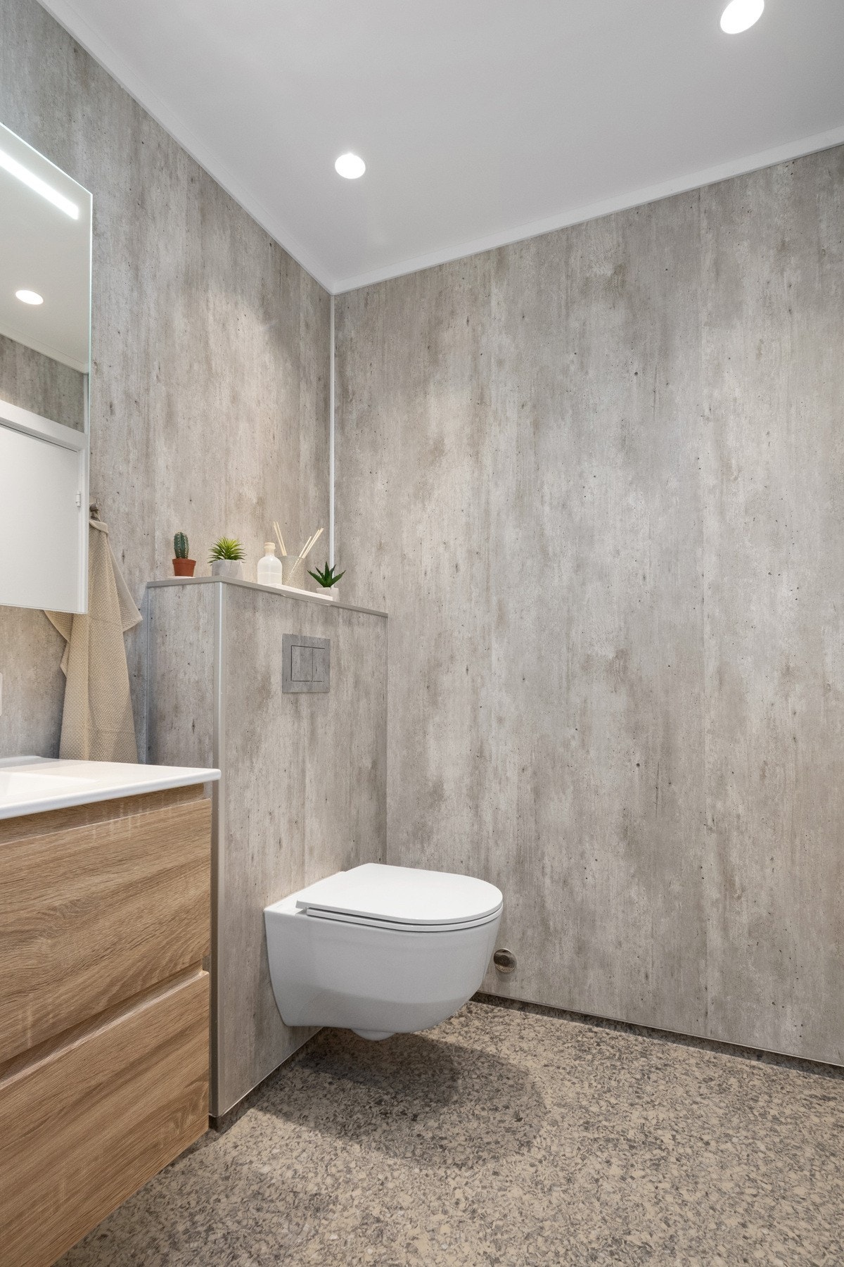 Badet har vegghengt toalett, servant med skuffer i treutførelse og speilskap med integrert belysning. Galleribilde