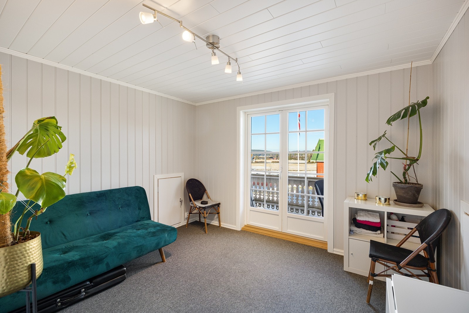 Loftstuen har tofløyede verandadører ut til en nordvestvendt veranda med overbygg. Galleribilde