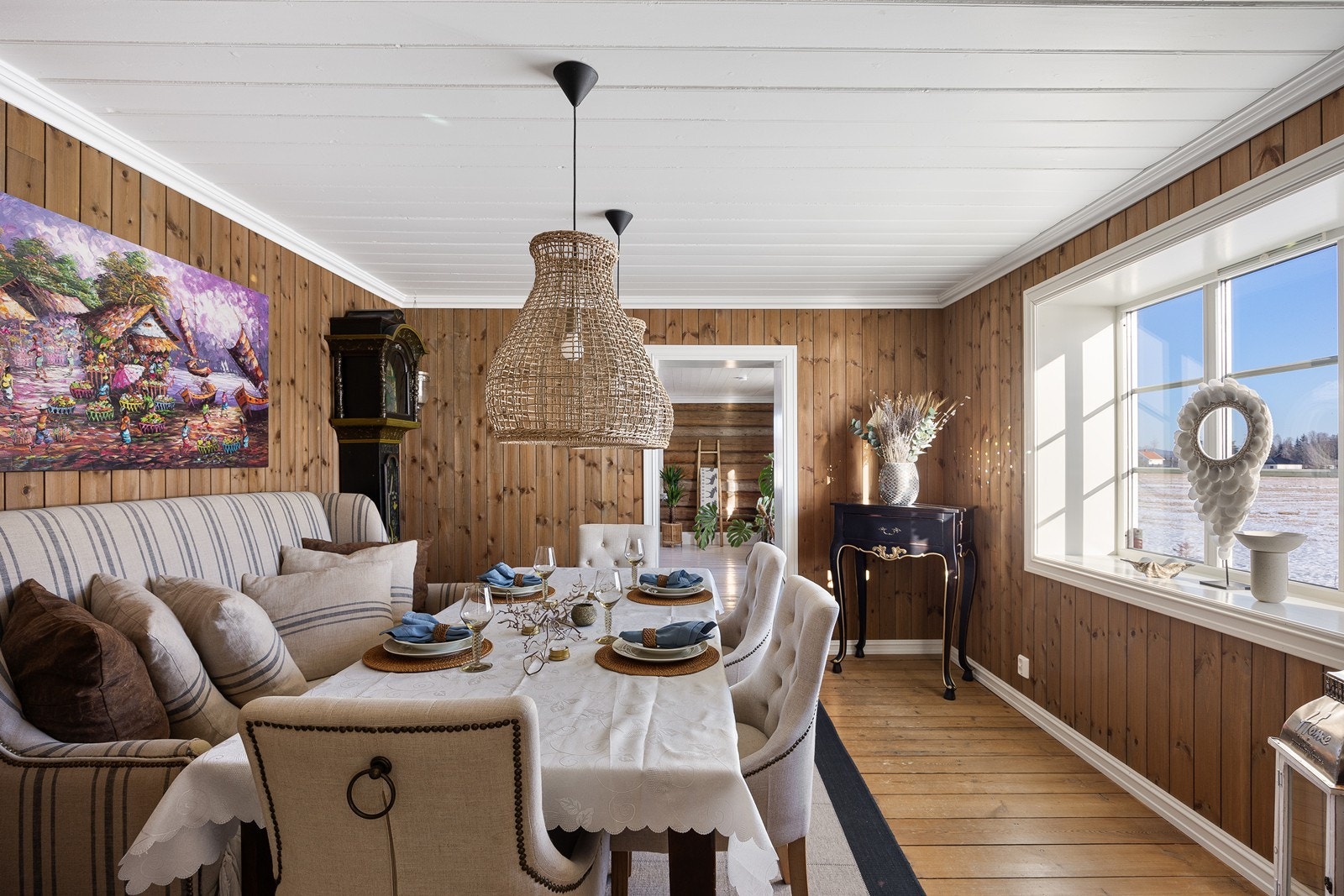 Intim og koselig spisestue med naturlig lys fra et stort vindu. Galleribilde