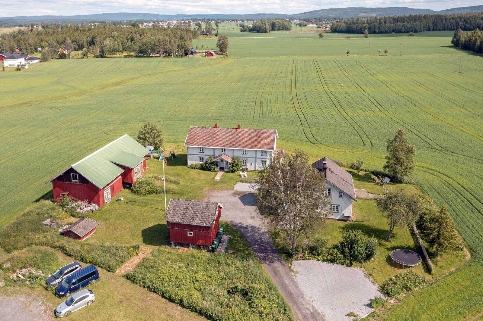 Utsikten strekker seg over åpent åkerlandskap med nærhet til skog og mark. Galleribilde