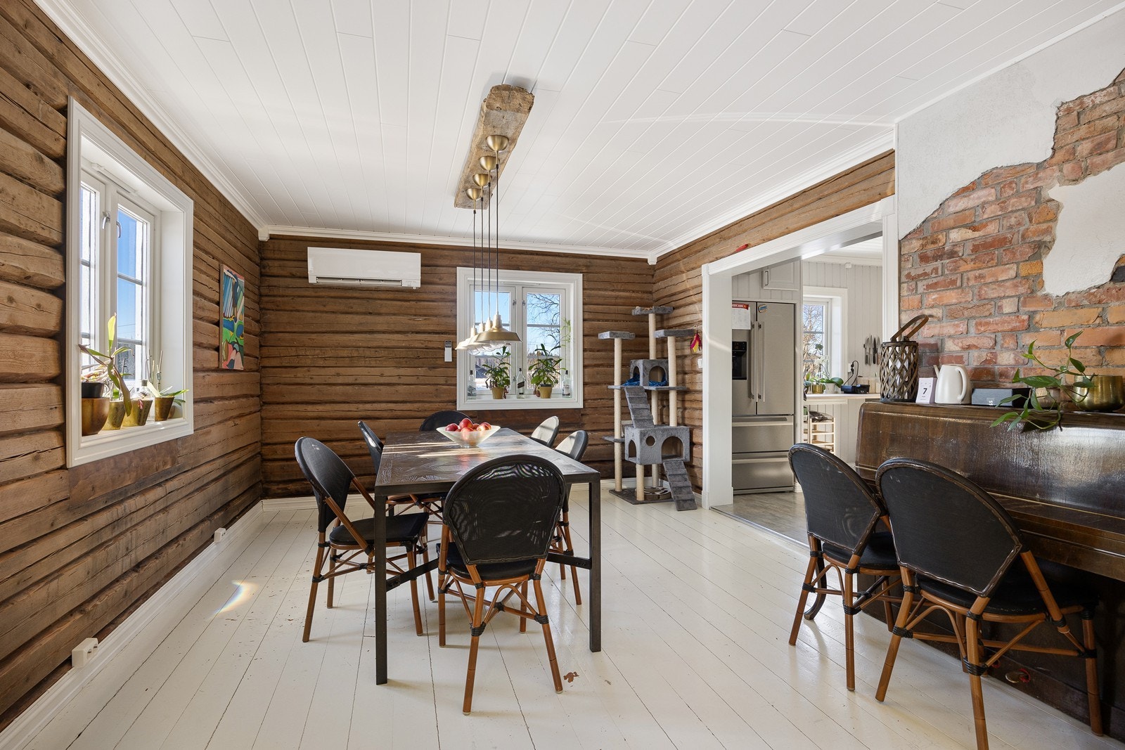 Spisestue i åpen løsning til kjøkkenet. Varmepumpe på vegg i spisestuen. Galleribilde