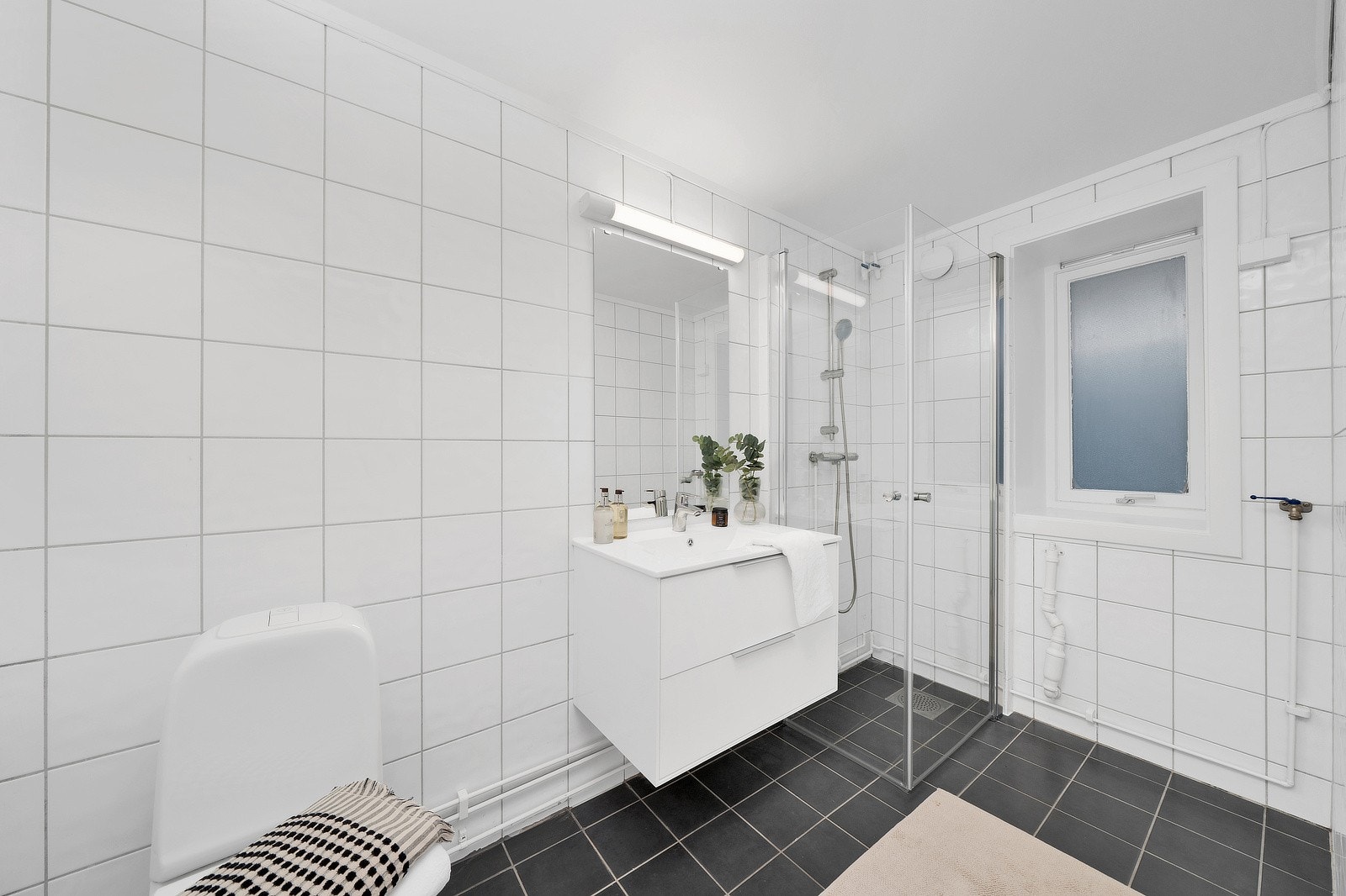 Helfliset bad med ny servantinnredning og innfellbare dusjvegger. Det er opplegg og plass til vaskemaskin. Galleribilde