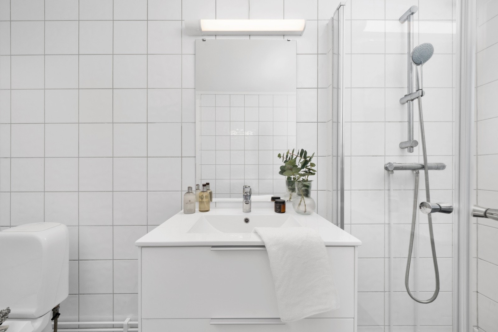 Badet har moderne innredning med nedfelt servant, montert i 2025, toalett, dusjhjørne med glassvegger, samt opplegg/ plass for vaskemaskin Galleribilde