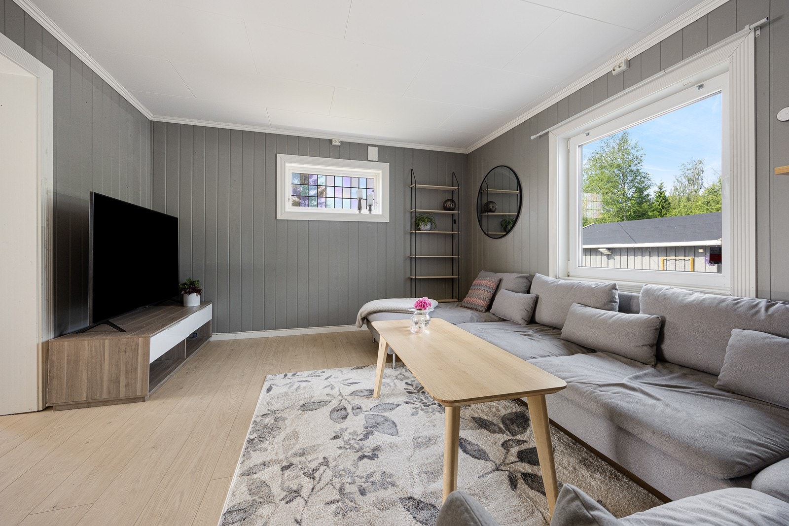 Sofasonen har en behaglig gråfarge på veggene som gir denne delen av stuen en lun følelse. Galleribilde