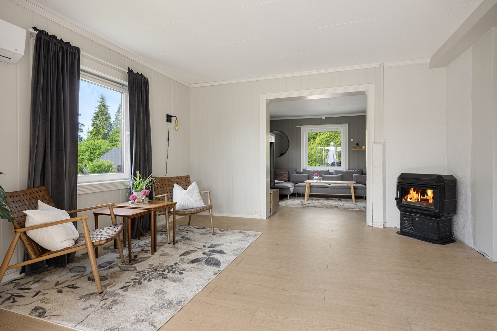 I én av stuene er det en eldre vedkamin, og i den tilliggende stuesonen ble det montert en luft-til-luft varmepumpe i 2023. Galleribilde