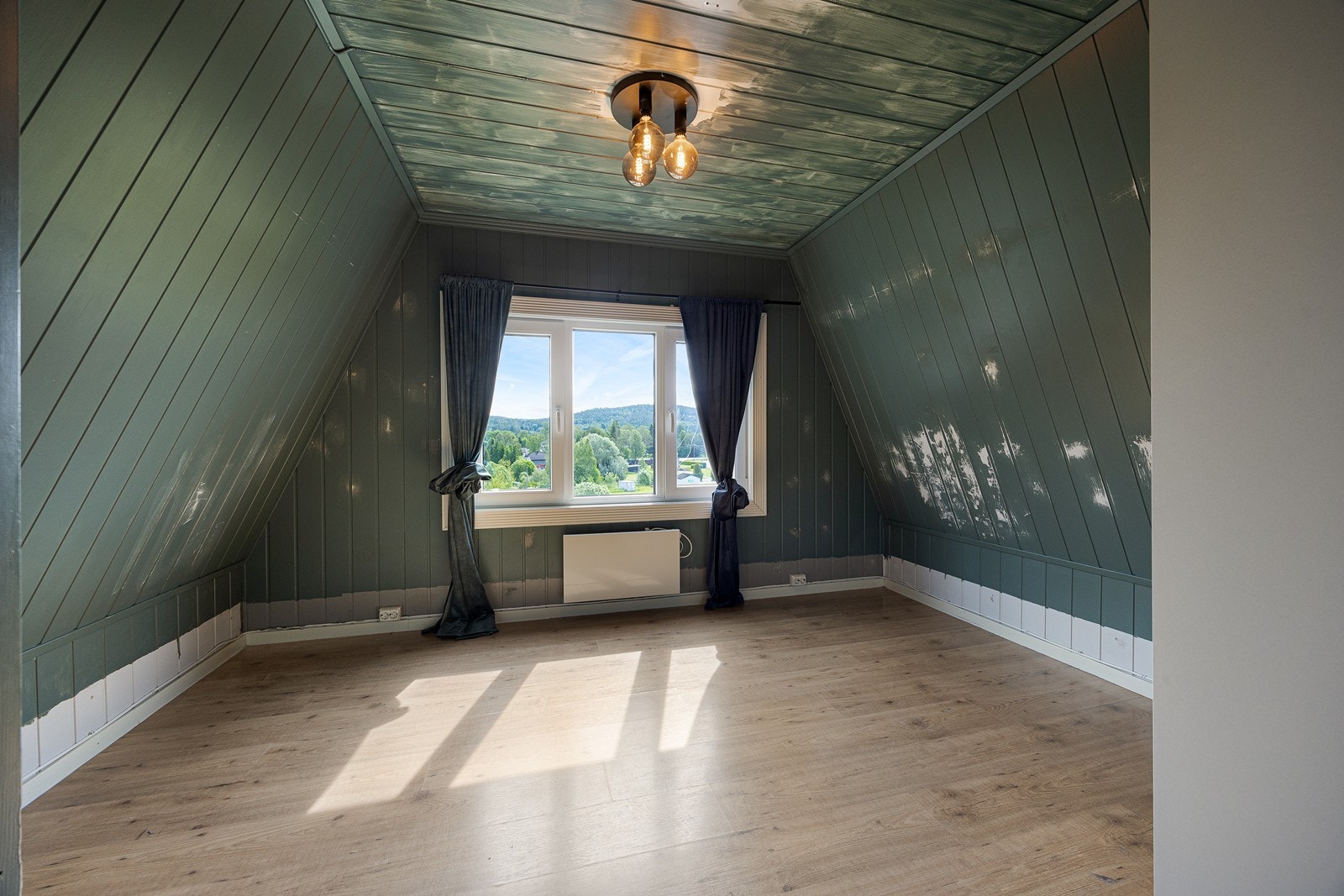 Dette rommets store og tredelte vindu byr på en langstrakt og naturskjønn utsikt. Galleribilde