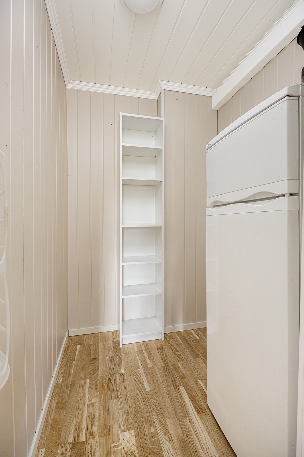 Tilliggende kjøkkenet er det et spiskammers med plass til hyller og ekstra kjøleskap. Galleribilde