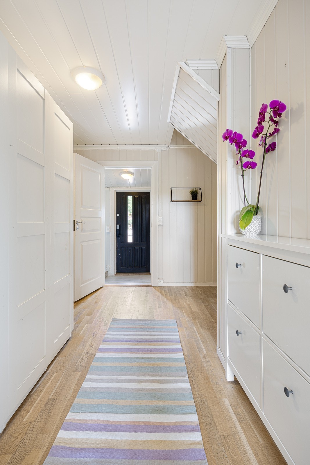 Innenfor entreen er det en luftig trappegang med et stort garderobeskap. Galleribilde