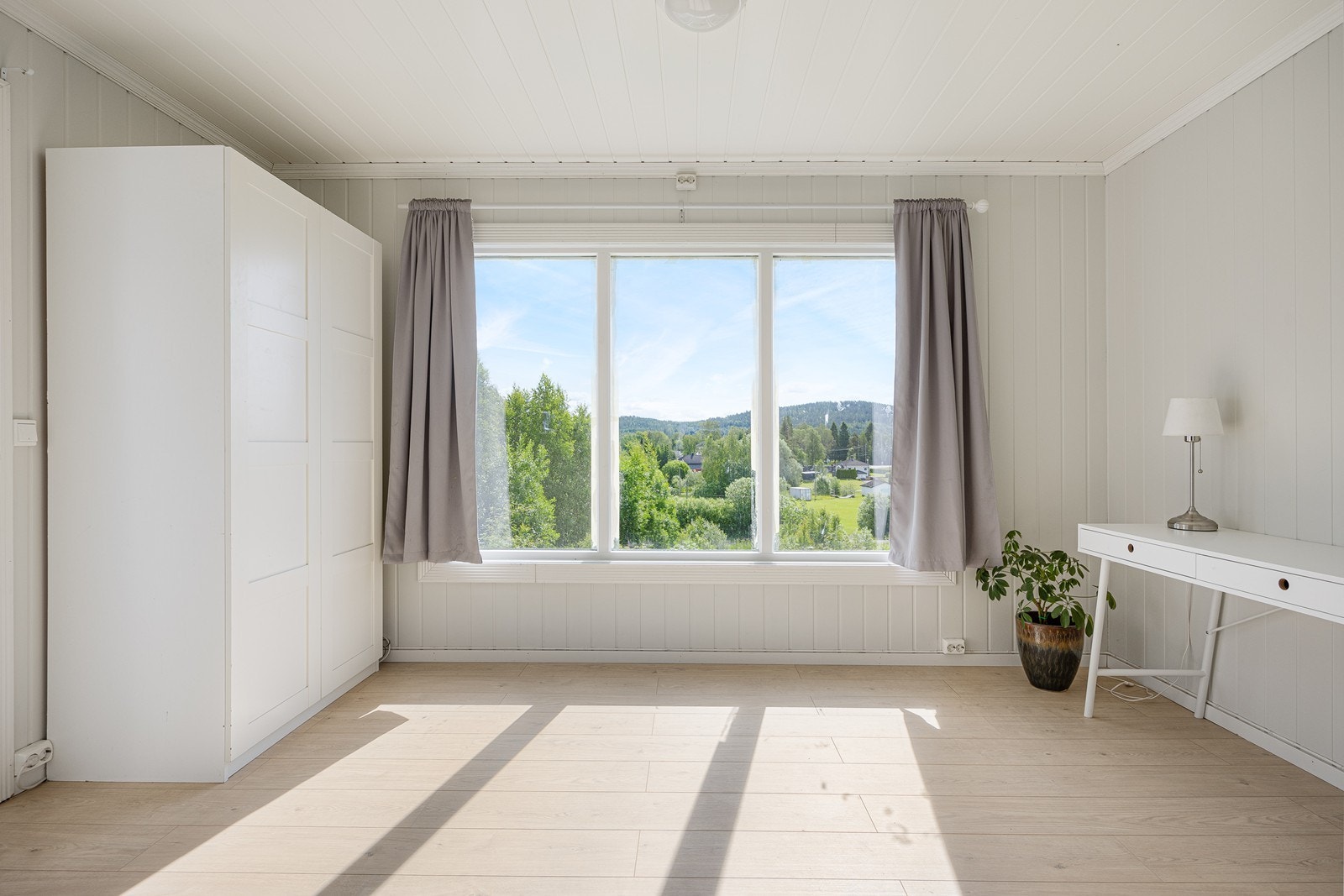 Denne delen av stuen vender ut mot hagen på baksiden av boligen. Det store vinduet gir rikelig med lysinnslipp til hele den åpne sonen. Galleribilde