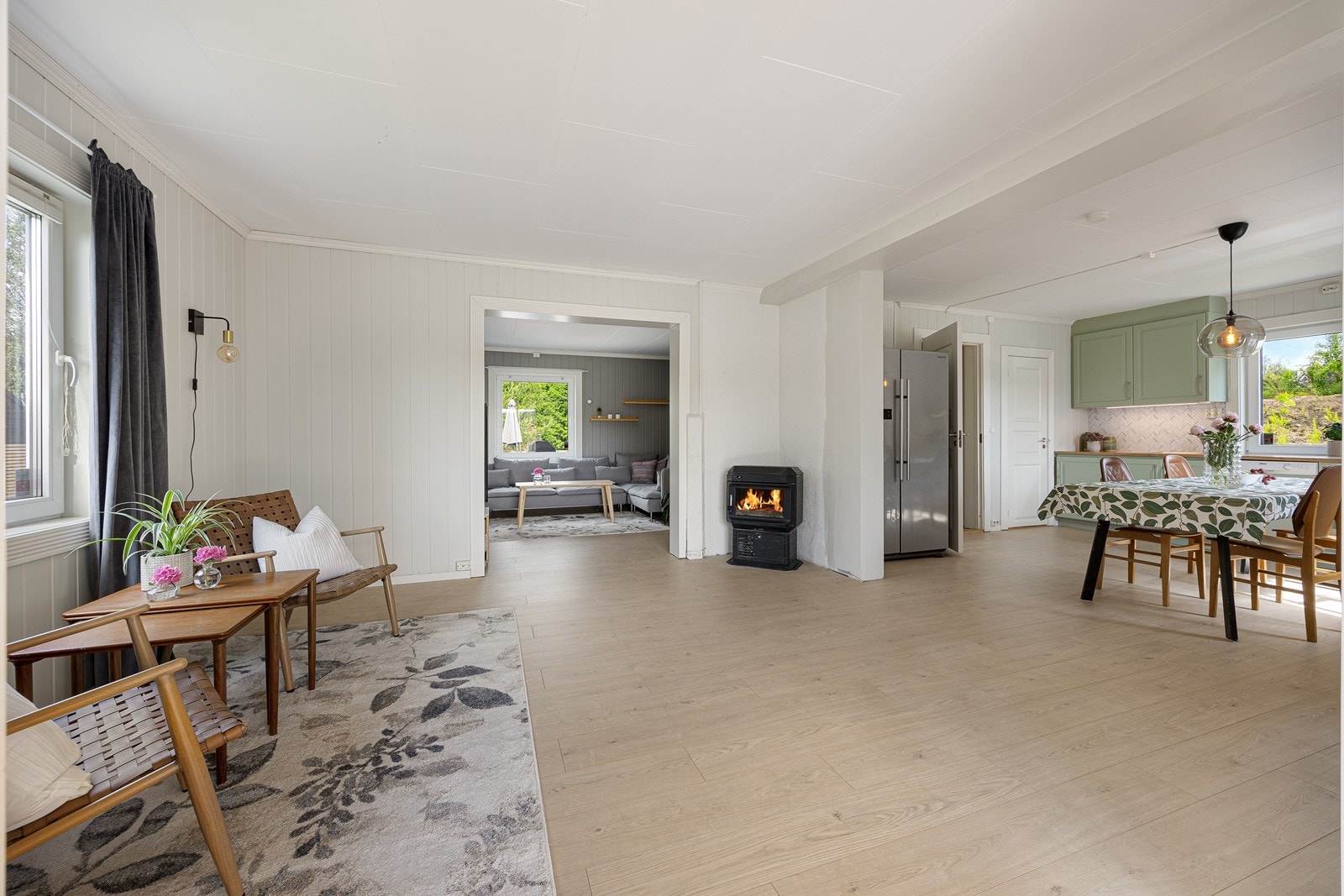 Det er tre innbydende stuer i eneboligens første etasje, og alle ligger i dels åpen løsning langs hele husets sydside. Galleribilde