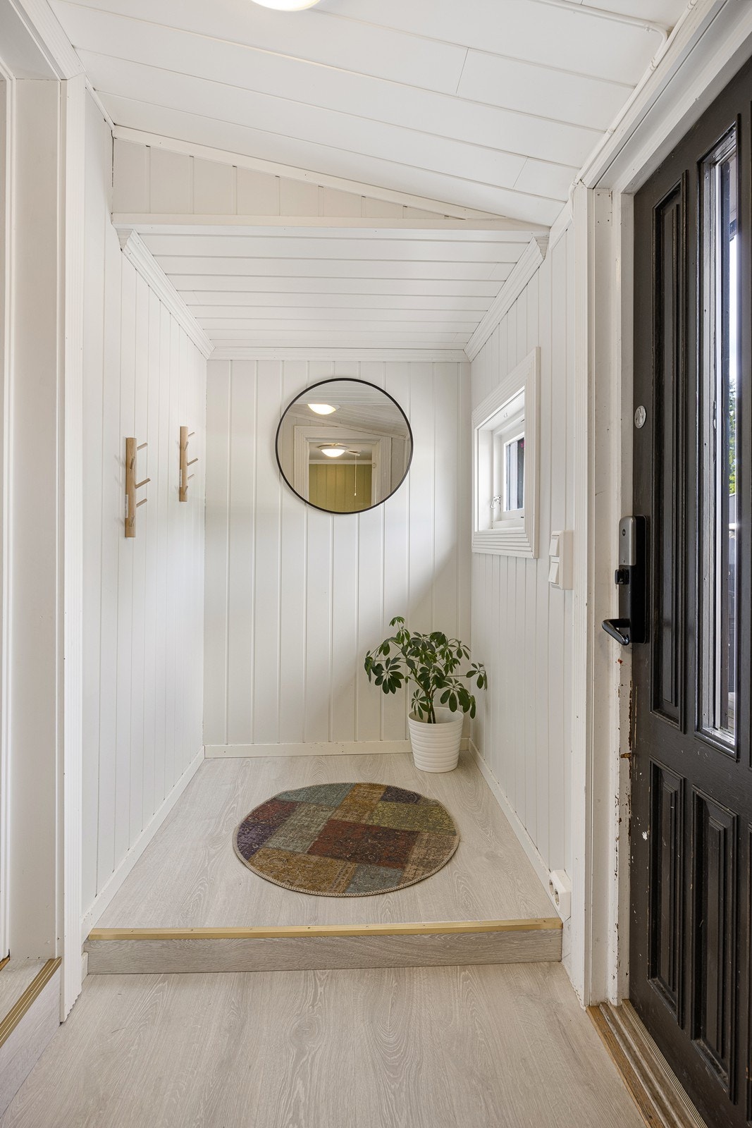 Entreen har lyse overflater og garderobenisje. Galleribilde