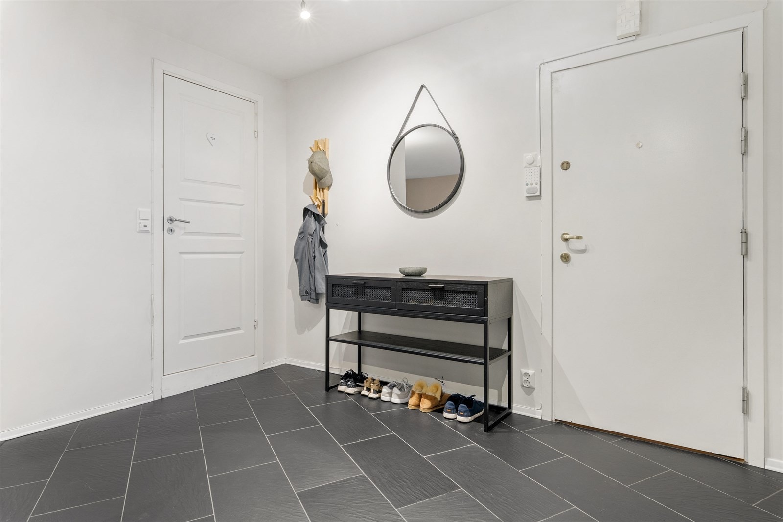 Det er flislagt gulv, og hvit malte vegger. Det er adkomst til resten av boligen fra rommet Galleribilde