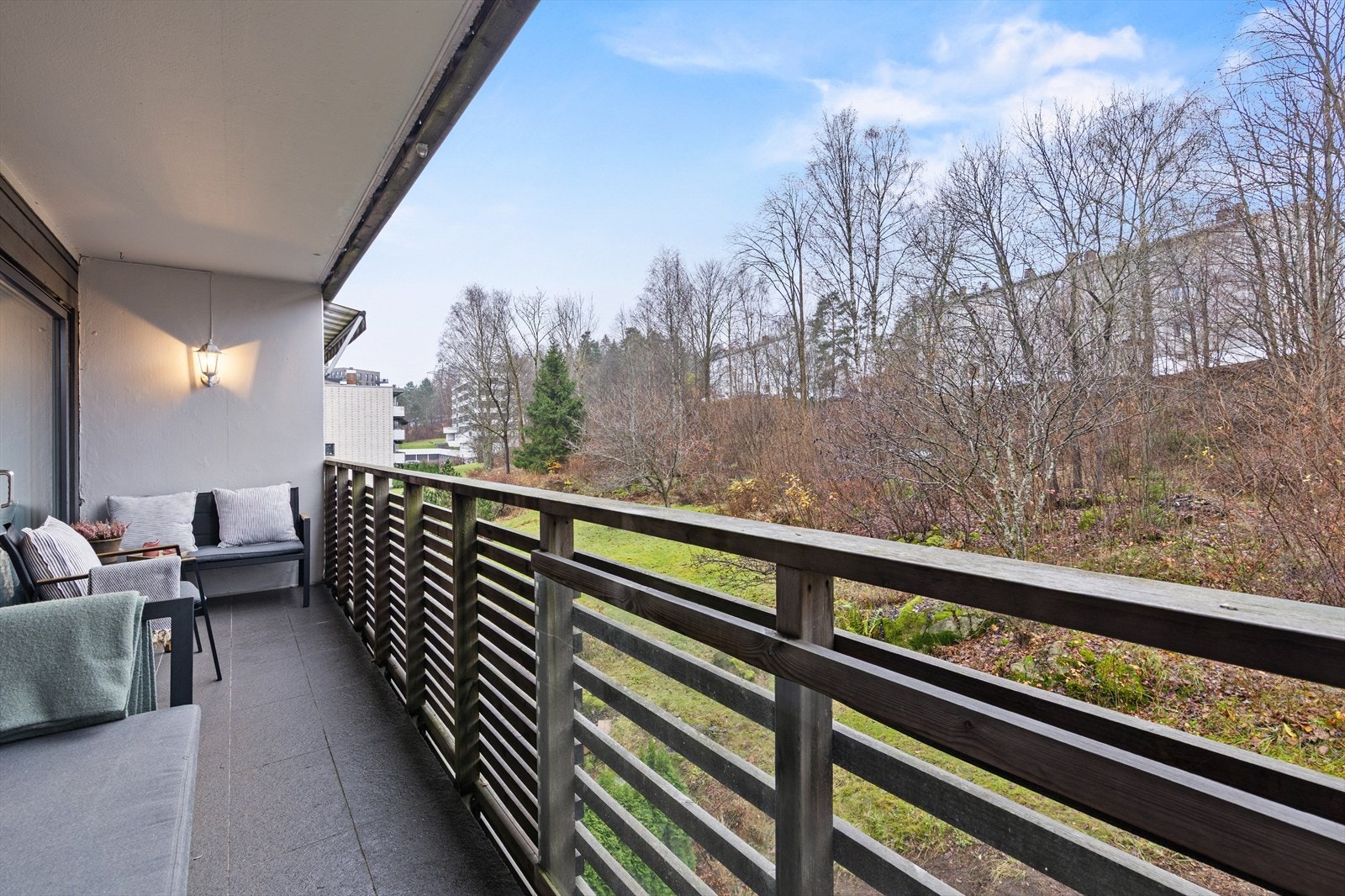 Fra terrassen er det utsikt mot et hyggelig skogholt og store grøntarealer Galleribilde