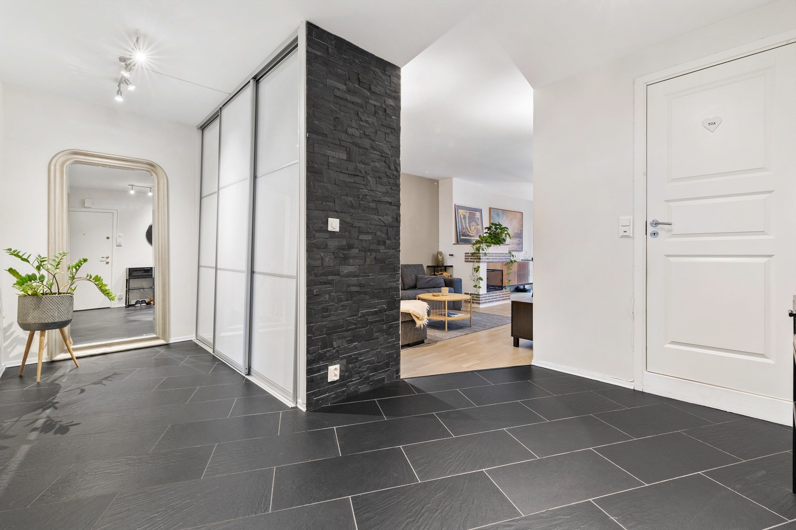 Romslig og innbydende entré med god plass til oppbevaring i stor plassbygget garderobe Galleribilde