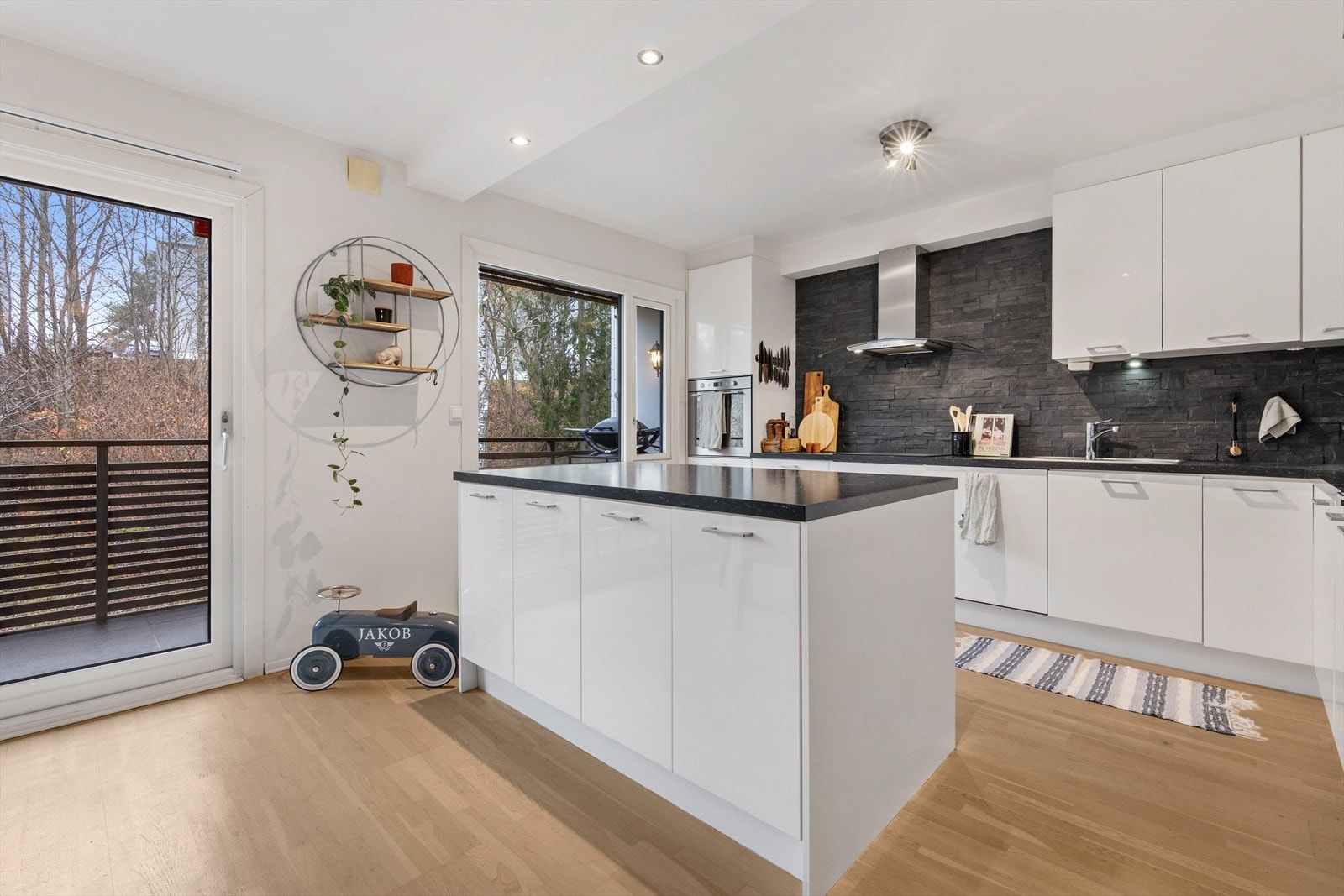 Kjøkkenet har hvite glatte fronter, og det er gode oppbevaringsmuligheter i skap og skuffer Galleribilde