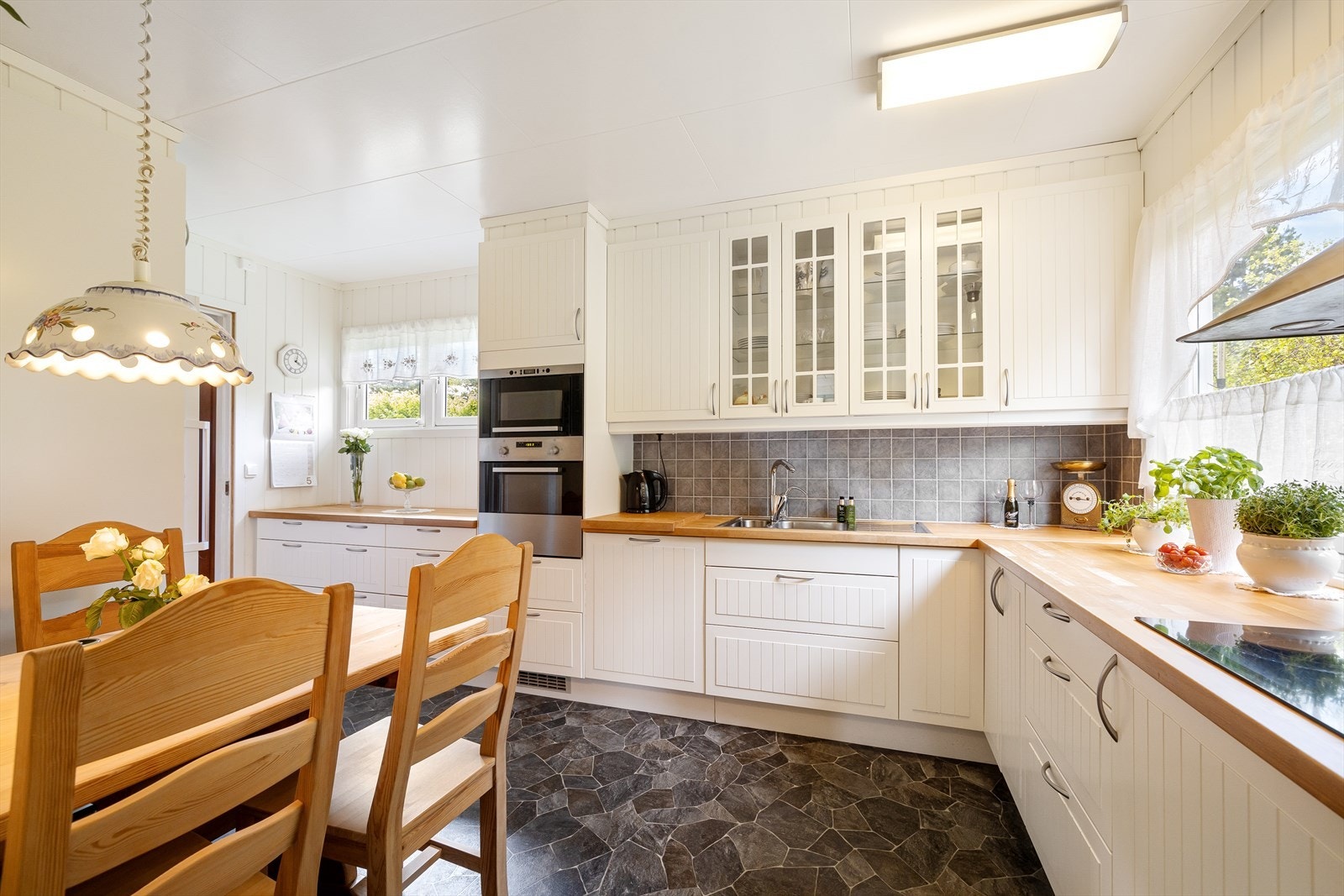 Kjøkkeninnredning med glatte fronter og heltre benkeplate. Det er integrert stekeovn, platetopp og oppvaskmaskin i kjøkkenet. Galleribilde