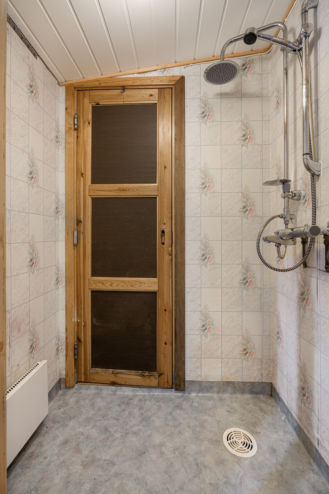 Dusjrommet har gulvbelegg og våtromstapet på veggene, panelovn, samt et åpent dusjhjørne. Galleribilde