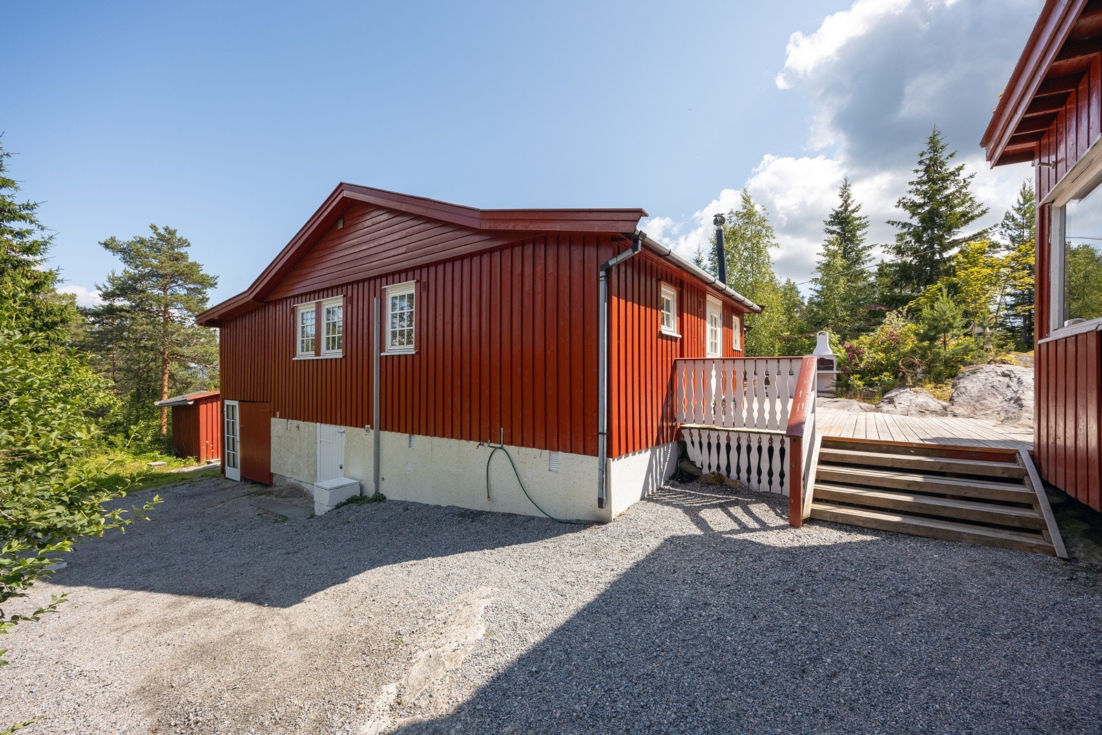 Nedenfor hytta har tomten en gruslagt gårdsplass for parkering. Galleribilde