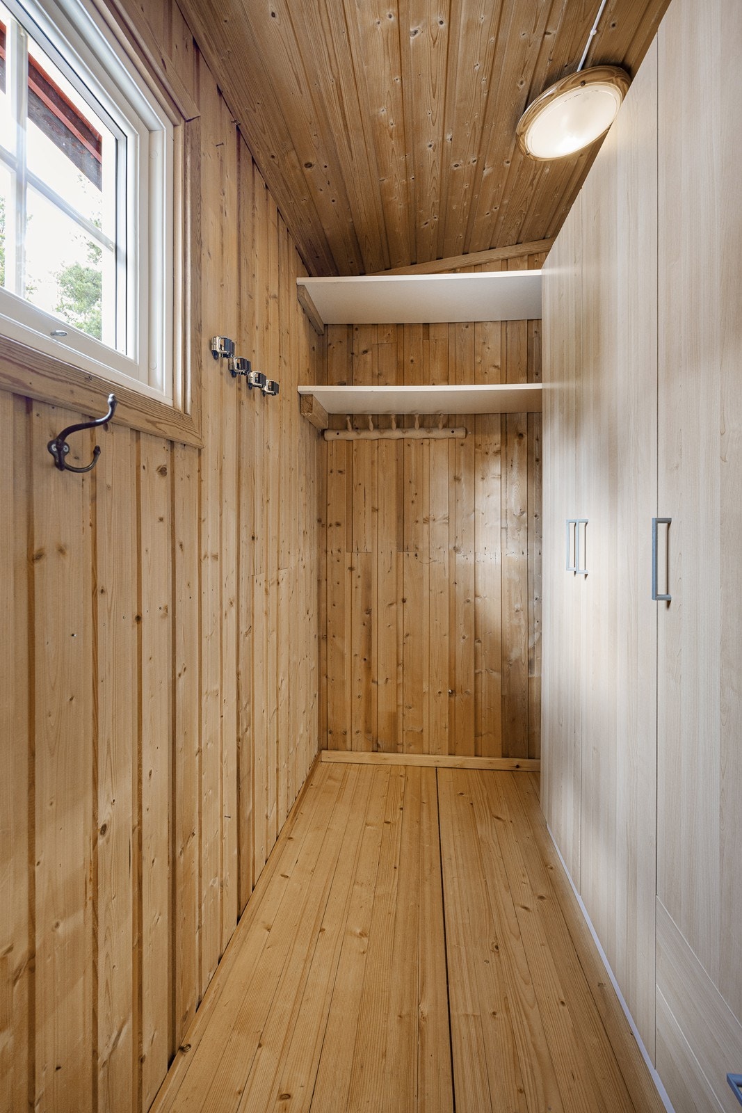 Ved entreen har hytta en praktisk bod med plassbygde hyller og et stort garderobeskap. Galleribilde