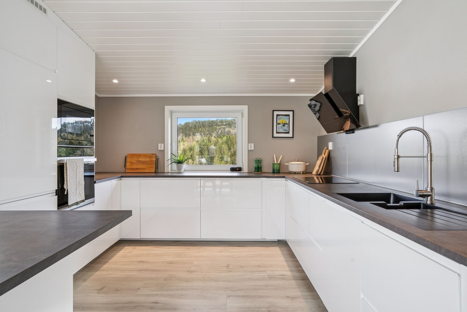 Romslig kjøkken med integrerte hvitevarer og halvøy Galleribilde