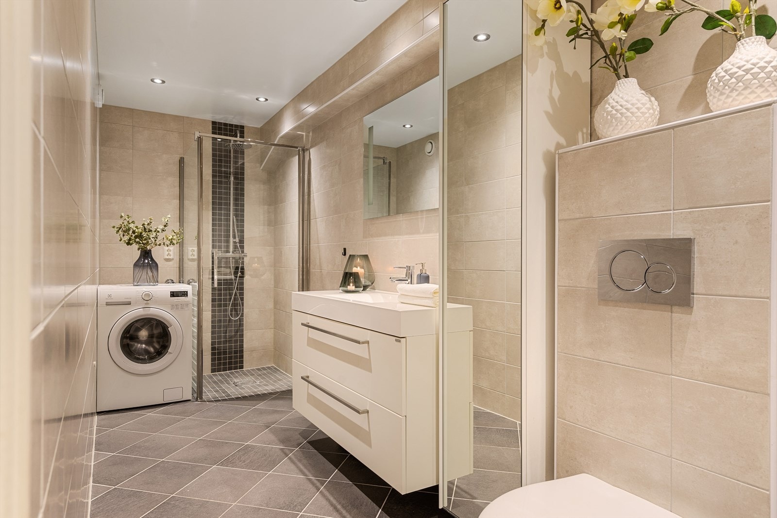 Badet er helfliset i tidløse farger og har gulvvarme som gir god komfort, samt downlights i himlingen for et moderne uttrykk. Galleribilde