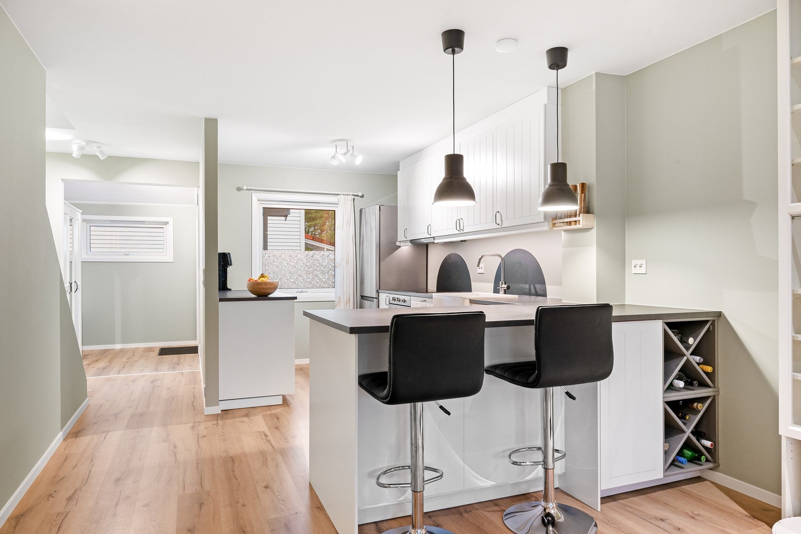 Romslig kjøkken i hvit utførelse med rikelig med skap- og benkeplass. Galleribilde