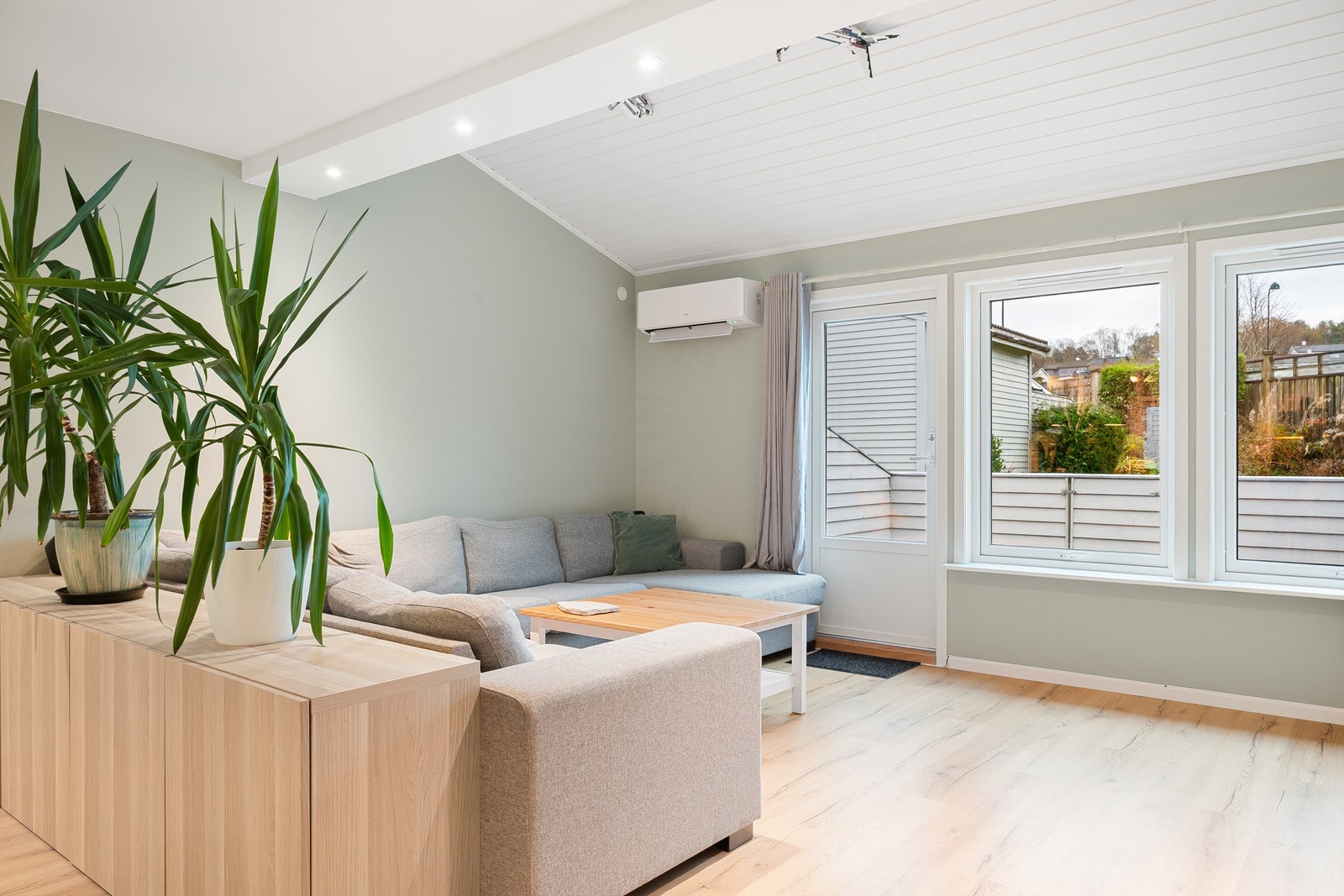 Stue malt i moderne farger med gode vindusflater som slipper inn mye naturlig lys. Det er også direkte utgang til terrasse fra stue. Galleribilde