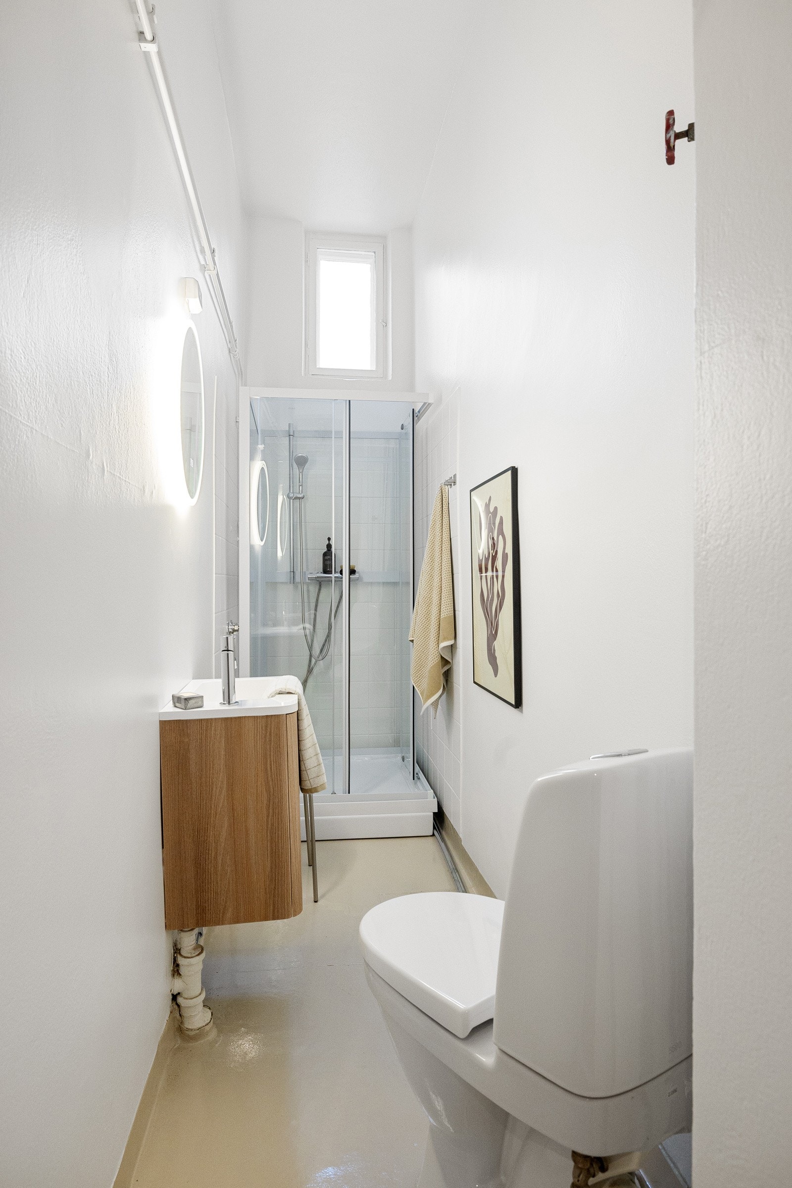 Badet er innredet med toalett, dusjkabinett og servant med servantskap i treverk. Galleribilde