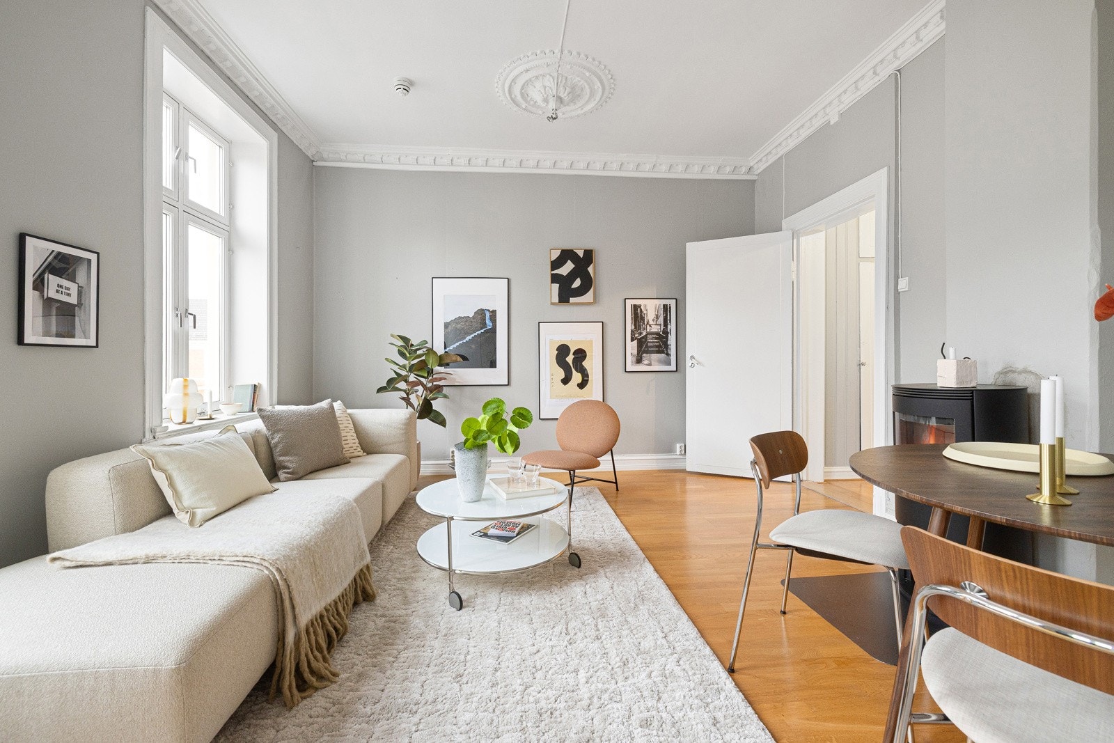 Stuen fremstår som et lyst og innbydende rom med klassiske detaljer som stukkatur og takrosett som gir et elegant preg. Galleribilde