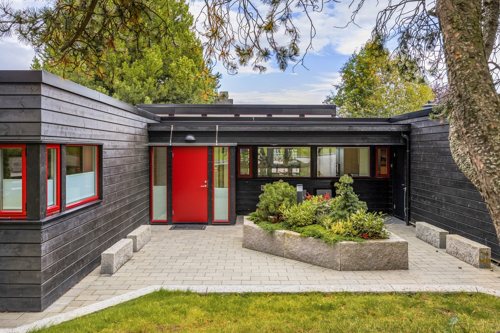 Det er arrondert og lagt nytt betongsteindekke ved adkomst og steinlagt plass i atriet, samt etablering av belysning. Galleribilde