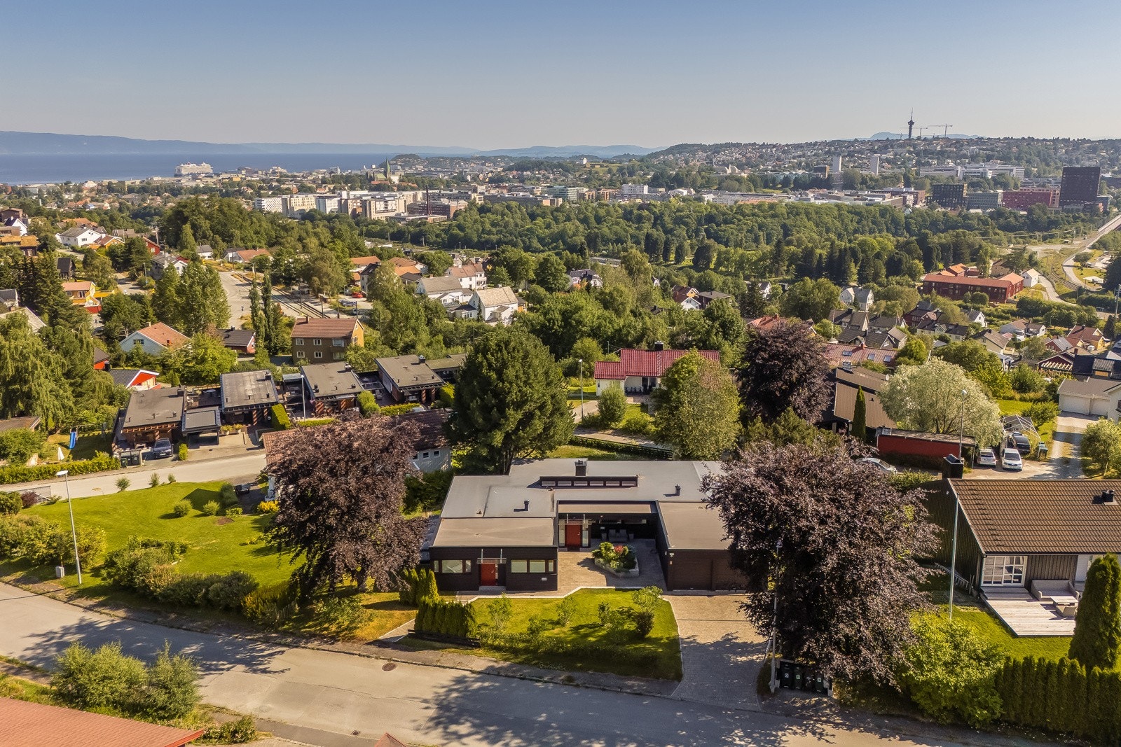 Dronebilde viser boligmiljøet mot utsikten over byen. Galleribilde