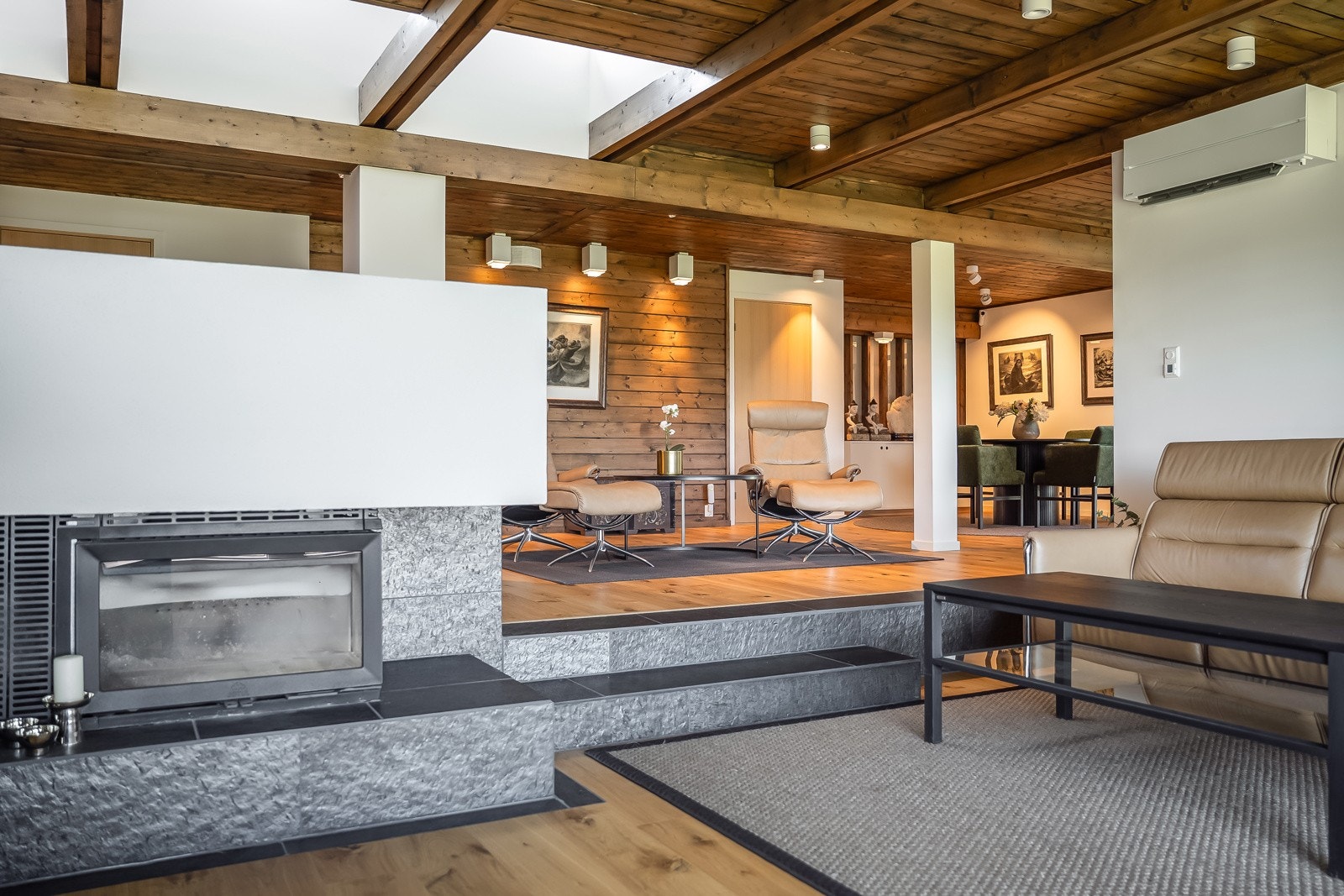 Midt i stua ligger en grandious peis utført i den eksklusive pillarguri-skifer med en ny, rentbrennende peisinnsats. Galleribilde