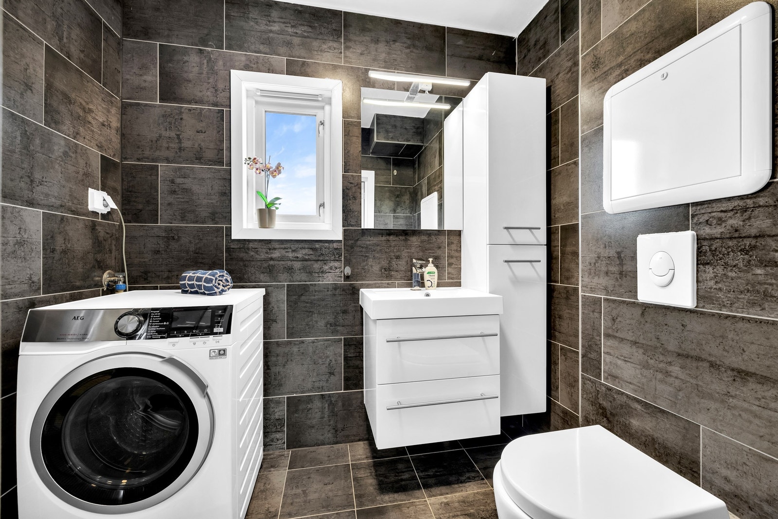 Flislagt baderom fra 2016 med behagelig gulvvarme. Moderne innredning og opplegg for vaskemaskin og tørketrommel. Galleribilde