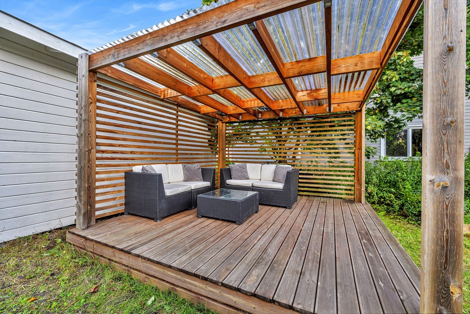 Pergola med tak hvor det er god plass til utemøbler og grill Galleribilde