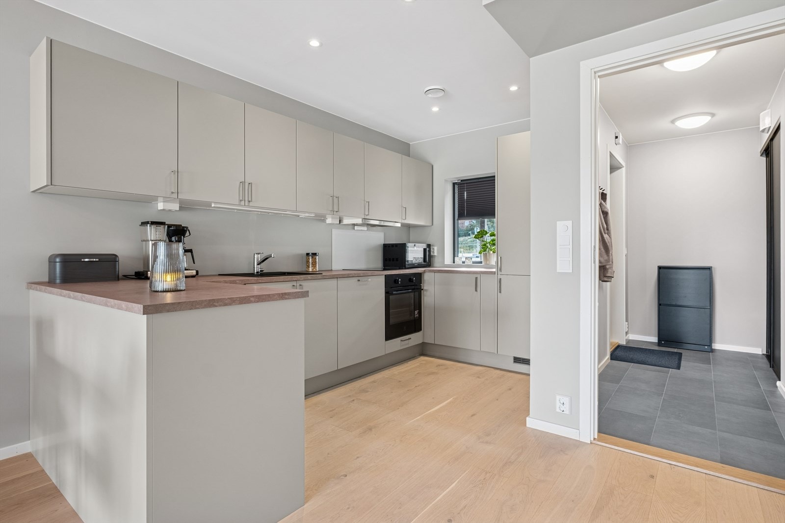 Moderne kjøkkeninnredning med glatte fronter, laminat benkeplate og nedfelt vaskekum. Galleribilde