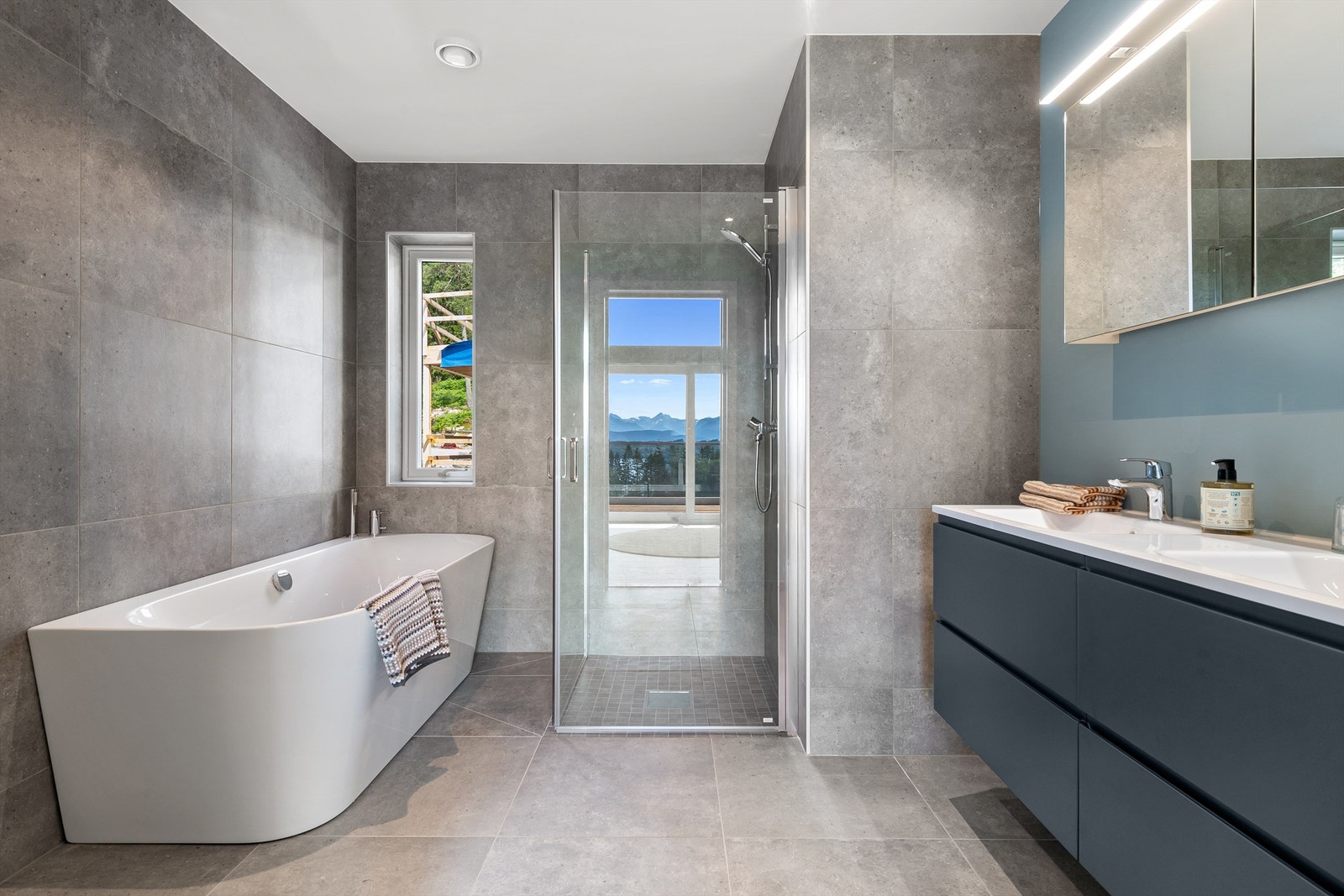 Bad i 2. etasje er innredet med badekar, dusjhjørne, vegghengt toalett og baderomsinnredning med dobbelservant. Galleribilde