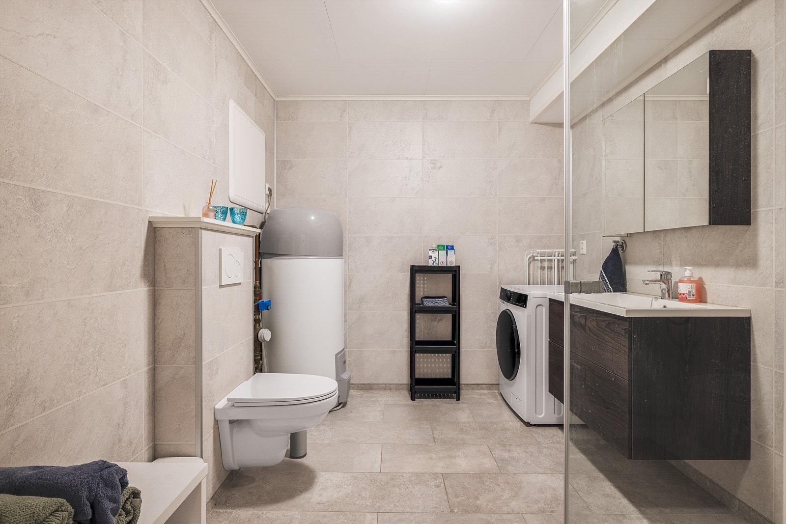 Badet er lyst og pent, med flislagt gulv med varmekabler og våtromsplater på veggene Galleribilde