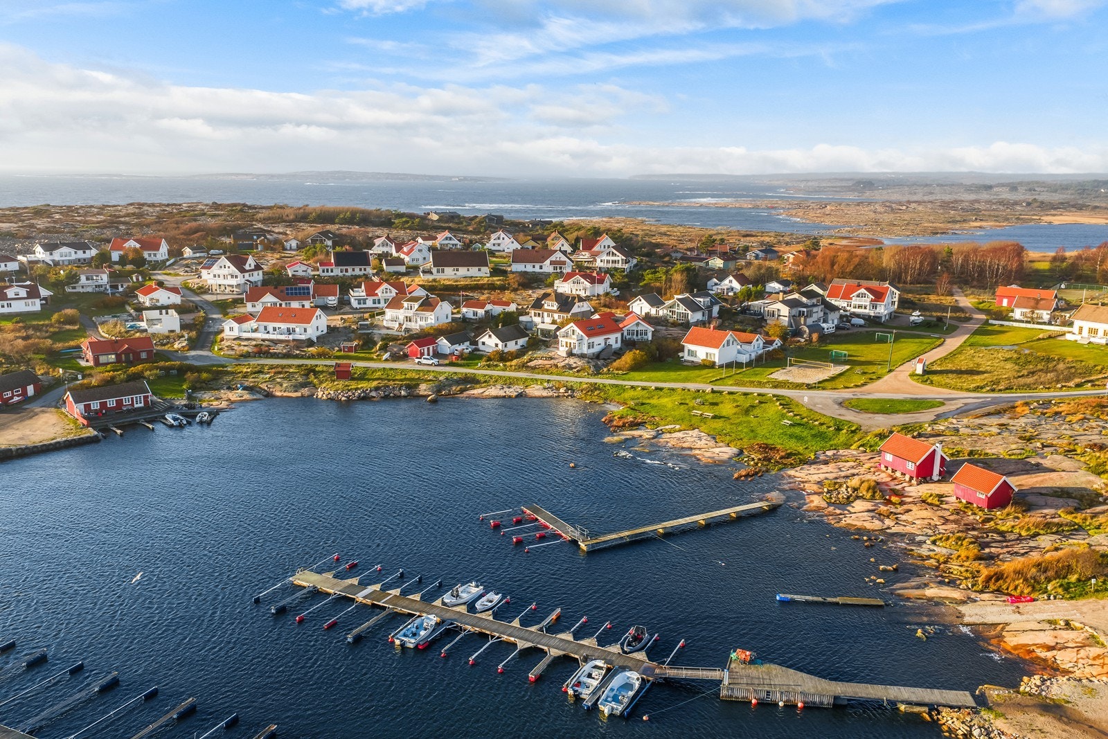 På sjøsiden av veien er det en gressbakke med krakker og en liten strand Galleribilde
