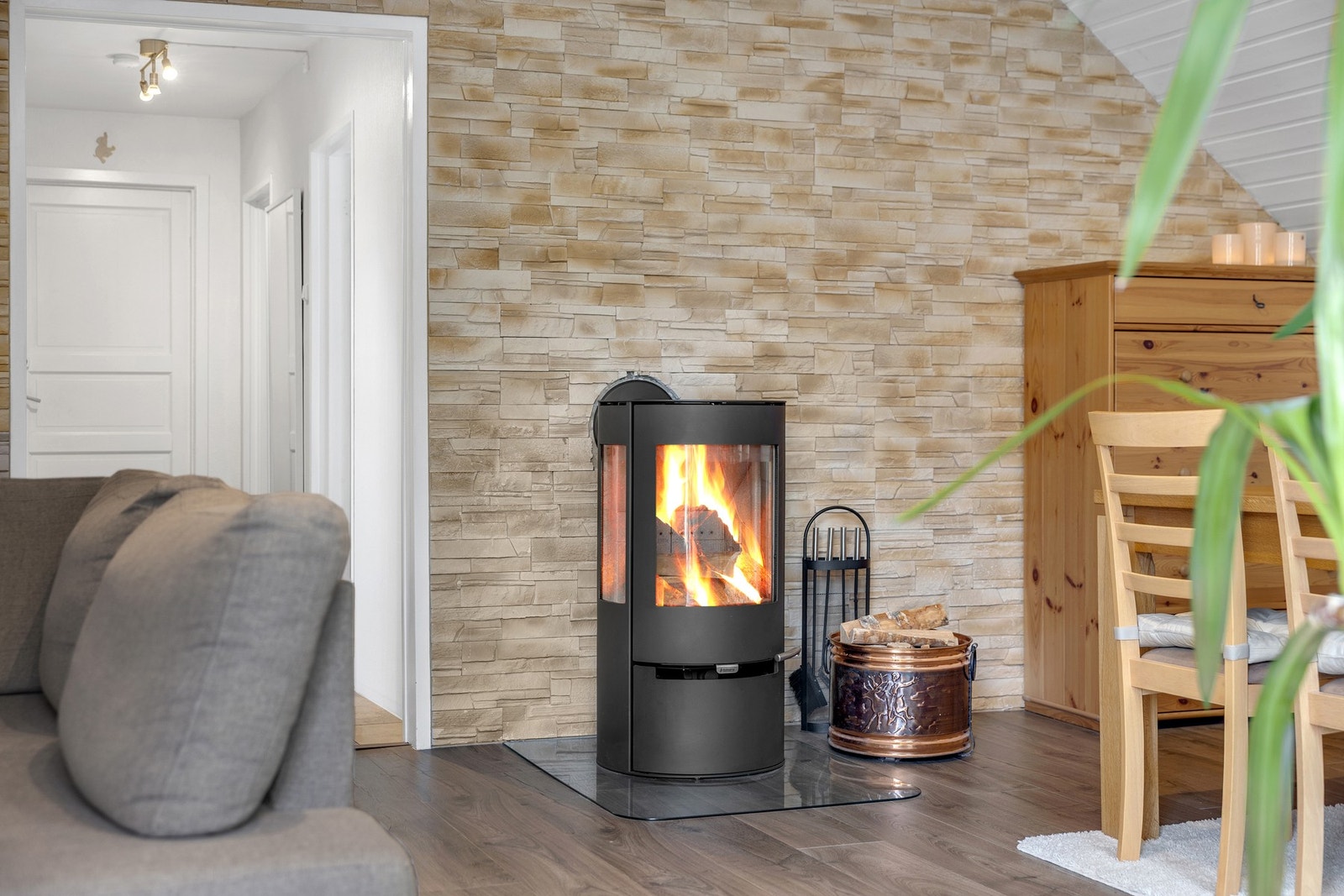 Leiligheten får lun varme og god stemning fra en moderne vedovn. Galleribilde