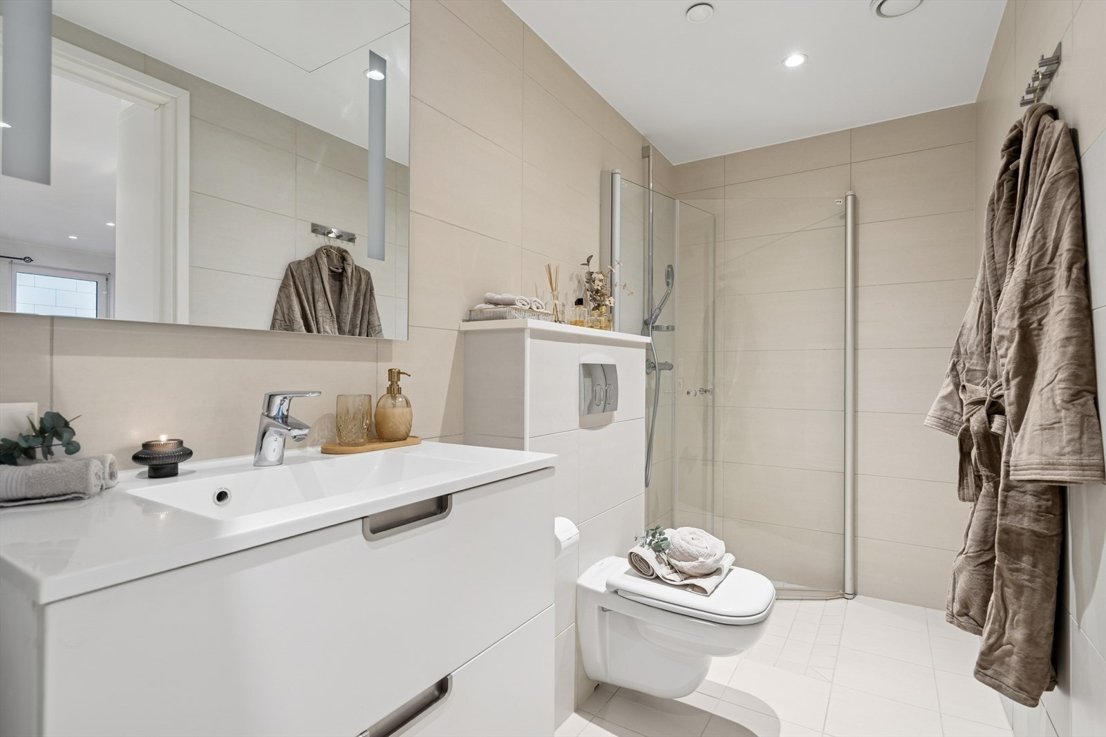 Her finner du dusjhjørne m/innfellbare glassdører, vegghengt toalett, baderomsinnredning og opplegg for vaskemaskin Galleribilde