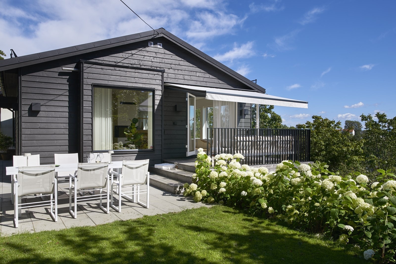 Idyllisk og skjermet tomt, pent opparbeidet med terrasse, platting, plen og beplantning Galleribilde