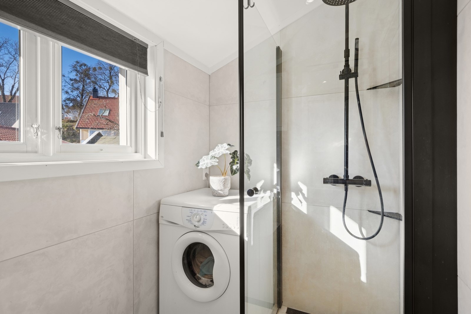 Her er det fliser på gulv og vegger, varmekabler og opplegg til vaskemaskin. Galleribilde