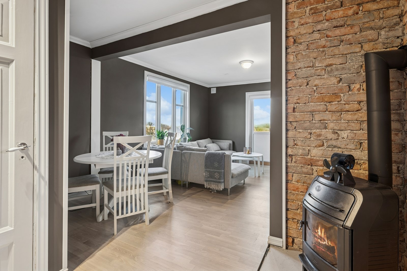 Stua har peis og eksponert teglstein som er en dekorativ detalj i rommet. Galleribilde