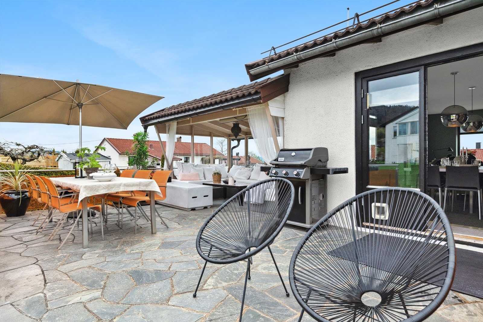 Fra stue med utgang til stor uteplass med overbygd sittegruppe og spiseplass. Perfekt for grilling på fine sommerdager. Galleribilde