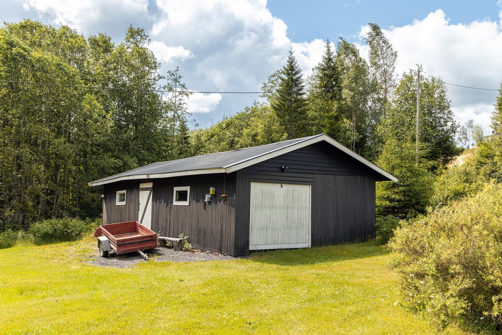 Det er parkering i en garasje og på egen, gruslagt gårdsplass. Garasjen ligger i samme bygg som et uthus som totalt måler ca. 68 kvm. Galleribilde