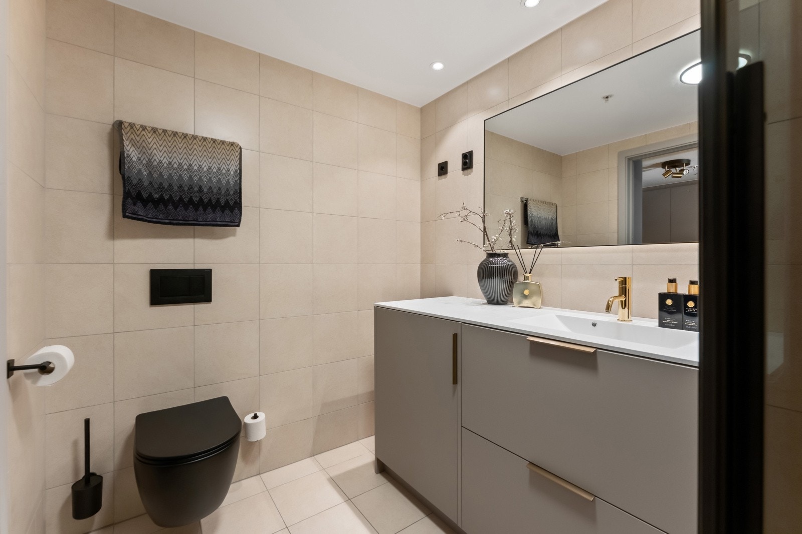 Boligen har et meget delikat og godt utnyttet bad, med ny integrert vaskemaskin/tørketrommel, varme i gulv og ekstra spotter i tak Galleribilde