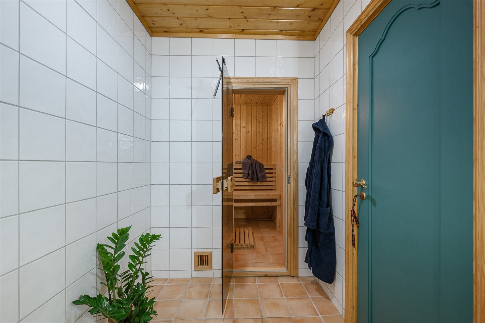 Badstue med plassbygd benk og flis på gulv. Galleribilde